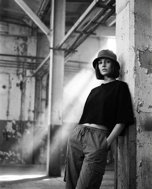 Frau in oversized Crop Top, Cargo Pants und Bucket Hat im Techno Rave Look