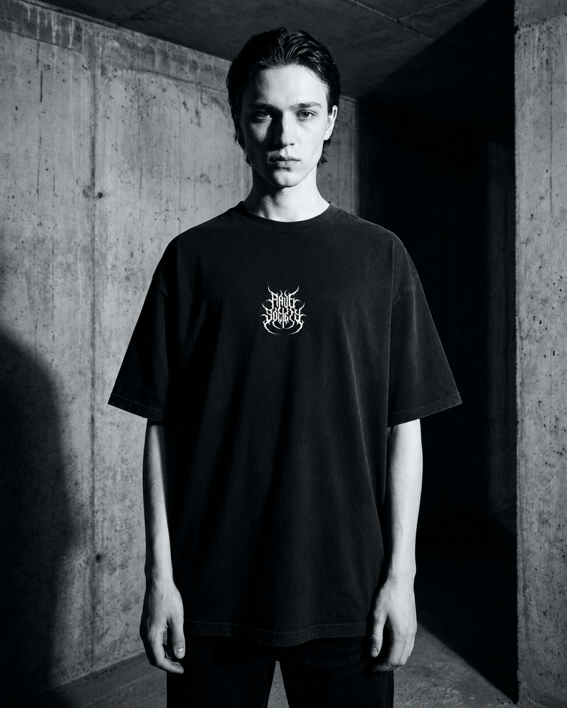 Model wearing the black Techno Connects oversized shirt, front view, brutalist industrial rave photoshoot